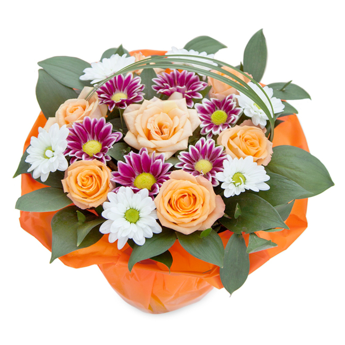 Evoking the spirit of Kingston upon Thames, this masterfully arranged bouquet radiates warmth and festivity from its central cluster of roses, each flower revealing soft gradients from peach to bold orange. These classic blooms are surrounded by white daisy-like chrysanthemums with light green or yellow eyes, juxtaposed with dense, magenta and purple chrysanthemums encircling bright green centres, adding vibrant energy reminiscent of the community's colourful local events. Abundant, dark layering foliage, likely ruscus, provides a verdant, glossy backdrop, echoing the shaded walks of Canbury Gardens. A slim, arching blade of bear grass graces the arrangement overhead, introducing a gentle contemporary flourish above the rich display. Wrapped in bright, crinkled orange cellophane at the base, the stems are tucked together, reflecting the bouquet's unified palette and sense of celebration. Expertly crafted for every occasion-from riverside birthdays to thank-yous on London Road-this bouquet embodies the attentive detail and care of Kingston upon Thames' most skilled florists, bringing artistry and colour into any local home with each delivery.